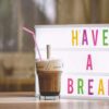 「HAVE A BREAK」と書かれたボードの前に置かれたコーヒーの画像