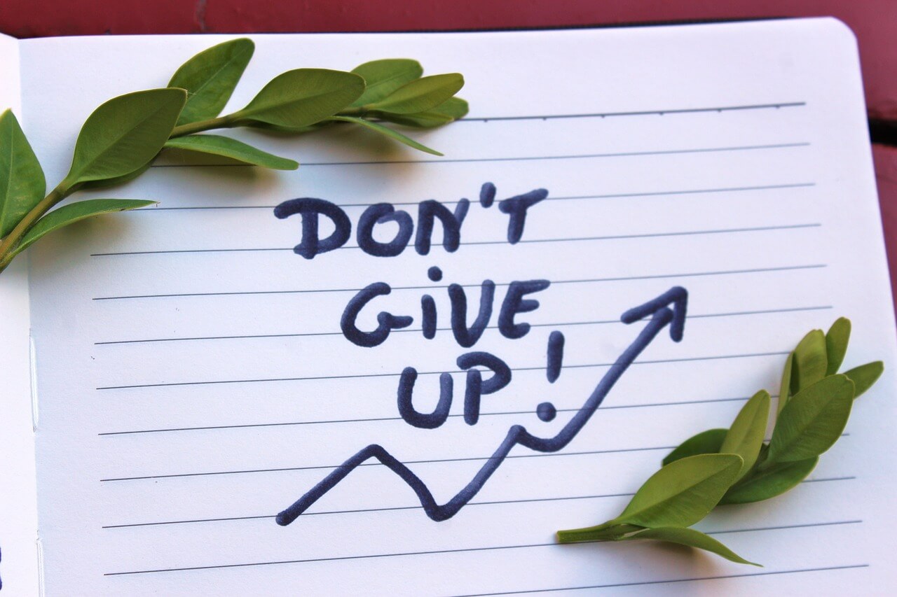 ノートに「Don't give up!」と書かれた画像