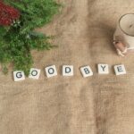 布の上にキャンドルと花と「GOODBYE」と書かれたブロックがおかれている画像