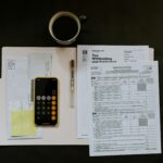 ボールペンの近くに黒いAndroidスマートフォン、白いフォルダの上に源泉徴収証明書